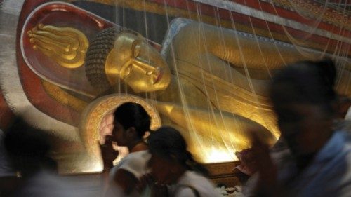 Buddhist devotees worship while walking through the inside of a temple, where Buddha statues have ... Buddhist devotees worship while walking through the inside of a temple, where Buddha statues have ...