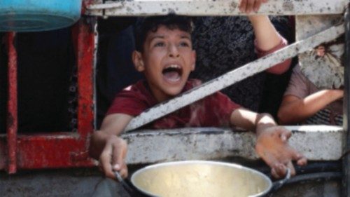 A Palestinian reacts as he waits to receive food from a charity kitchen, amid a hunger crisis, in ... A Palestinian reacts as he waits to receive food from a charity kitchen, amid a hunger crisis, in ...