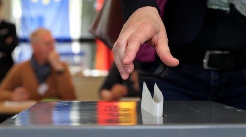 epa07601619 A woman casts his vote in the European elections at a polling station in Berlin, ...