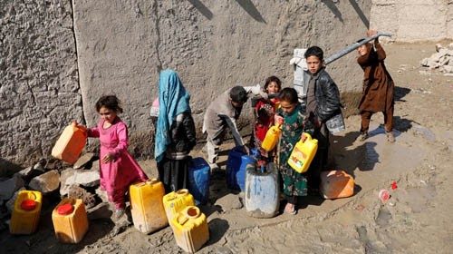 Internally displaced Afghans collect water from a public water pump next to their tents at a refugee ...