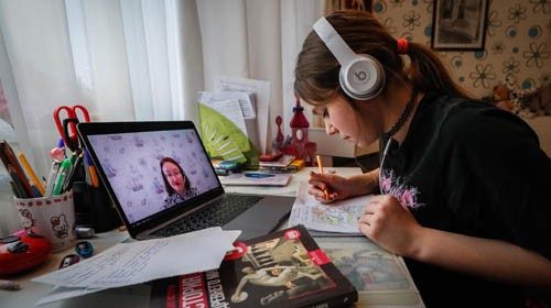 epa08331365 A student writes in a notebook during an online video lesson with her history teacher,  ...