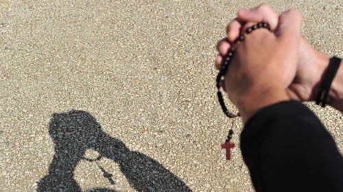 A boy who recites the 'Our Father' prayer with a rosary in his hand casts a shadow, after Pope ... A boy who recites the 'Our Father' prayer with a rosary in his hand casts a shadow, after Pope ...