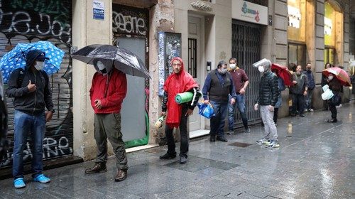 Persone davanti alla chiesa di S. Anna a Barcellona in attesa di pacchetti alimentari (Reuters) Persone davanti alla chiesa di S. Anna a Barcellona in attesa di pacchetti alimentari (Reuters)