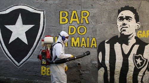A clean worker disinfects the streets of the Vidigal slum, following the coronavirus disease ...