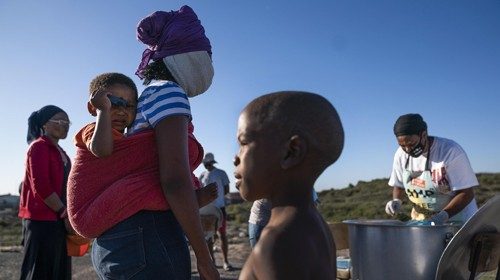 epa08390150 Community members wait to receive a meal in the informal settlement of Masincedane which ...