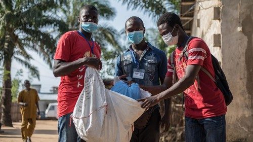 Agents show mosquito nets as they go door-to-door on April 28, 2020 in the Cotonou's district of ...
