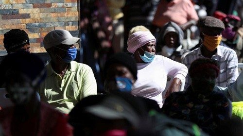 Men and women sit in a queue waiting for government grants as South Africa starts to relax some ... Men and women sit in a queue waiting for government grants as South Africa starts to relax some ...