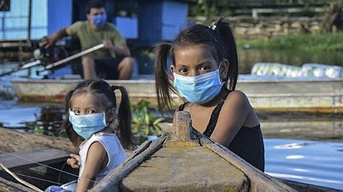 Two girls wearing face masks, as a preventive measure against the spread of the novel coronavirus, ...