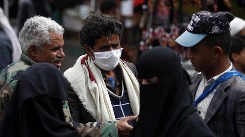 epa08420325 A Yemeni (C) wearing a protective face mask chats at a market in Sanaa, Yemen, 13 May ...