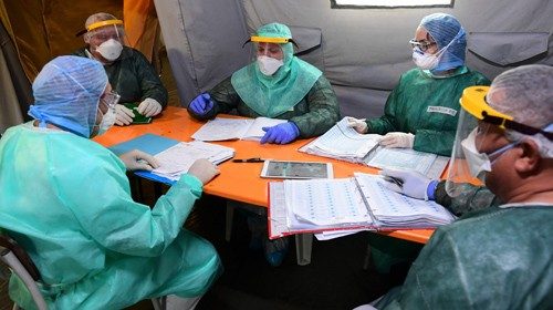 Cuban doctor Jose Enrique Ortiz (C) and Italian medical staff take part in a daily briefing in a ...