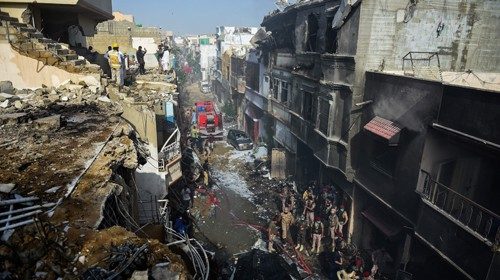 TOPSHOT - Rescue workers gather at the site after a Pakistan International Airlines aircraft crashed ...