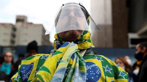 A supporter of Brazil's President Jair Bolsonaro wearing a face shield attends a protest against ...