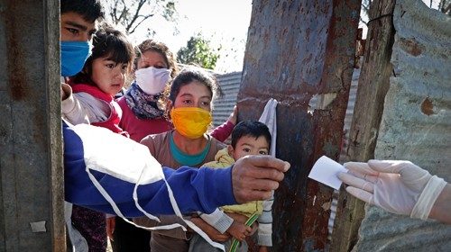 Operatori sanitari distribuiscono test olfattivi in una baraccopoli della provincia di Buenos Aires (Afp) 