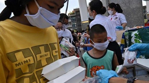 Distribuzione di aiuti alimentari in una parrocchia di Bangkok (Afp)