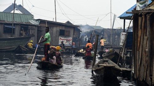 People sit in canoe to engage in daily activities at Makoko waterfront settlement in Lagos, on ...