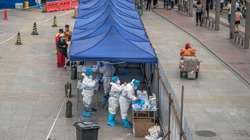 epa08490175 Medical workers wearing full protective suits prepare to test people for Covid-19 at a ...