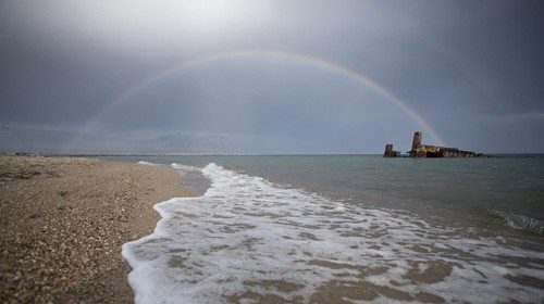 epa08492342 A rainbow appears in the sky after a storm over a shipwreck in a beach near the village ...