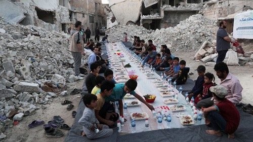 FILE PHOTO: People wait the call to prayer before they eat their Iftar meal provided by a group of ... FILE PHOTO: People wait the call to prayer before they eat their Iftar meal provided by a group of ...