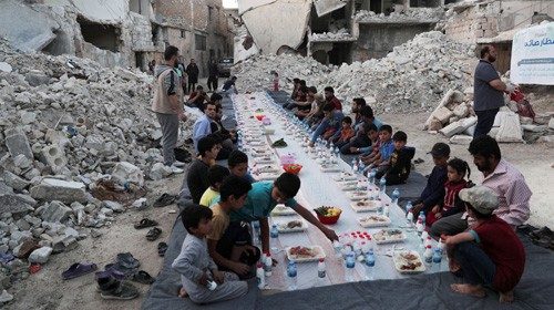 FILE PHOTO: People wait the call to prayer before they eat their Iftar meal provided by a group of ...