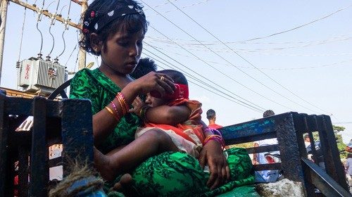 (FILES) In this file photo taken on May 24, 2020, a girl holds a baby at the Aung Mingalar ...