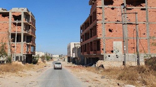A car advances on an empty road between damaged buidlings in the Salaheddin district south of the ... A car advances on an empty road between damaged buidlings in the Salaheddin district south of the ...
