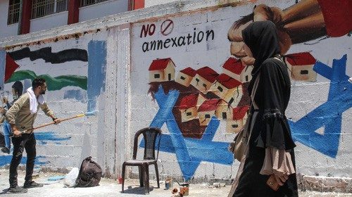 Un murale contro le annessioni dipinto a Rafah (Afp)