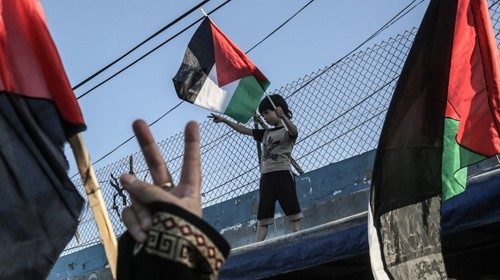 A Palestinian boy waves a national flag during a demonstration against Israel's West Bank annexation ...