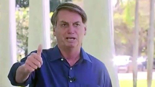 Brazil's President Jair Bolsonaro gestures as he speaks to the media on his positive coronavirus ...