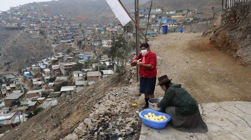 epa08527317 A woman prepares the common pot on a hill in Nueva Rinconada, in Pamplona, a ...