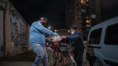 epa08524102 A man (R) receives a free meal outside a community center amid the ongoing coronavirus ...