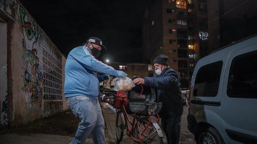 epa08524102 A man (R) receives a free meal outside a community center amid the ongoing coronavirus ...