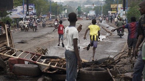 People run away at the arrival of the riot police as protesters set barricades to block the ...