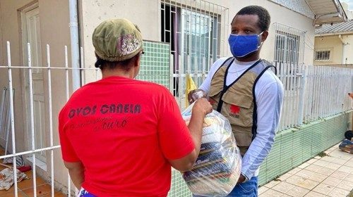 Distribuzione di viveri e vestiario da parte di un volontario della Caritas brasiliana