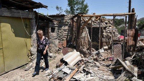 Una donna cammina tra le macerie di una fattoria bombardata durante gli scontri sul confine tra Armenia e Azerbaigian (Afp) Una donna cammina tra le macerie di una fattoria bombardata durante gli scontri sul confine tra Armenia e Azerbaigian (Afp)