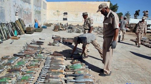 Militari dell’esercito di al-Serraj controllano armi ed esplosivi recuperati (Epa)