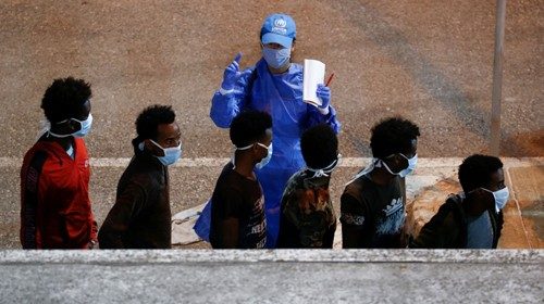 FILE PHOTO: Rescued migrants are being checked by a United Nations High Commissioner for Refugees ...