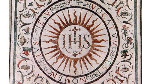 Il monogramma IHS raffigurato nelle Camerette di sant’Ignazio accanto alla Chiesa del Gesù a Roma (XVI secolo)