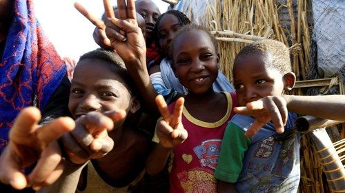 FILE PHOTO: Internally displaced Sudanese children gesture to the photographer as they play outside ...