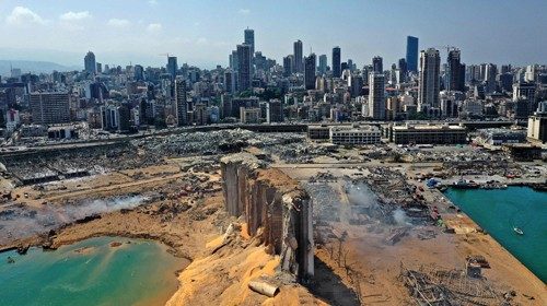 An aerial view shows the massive damage done to Beirut port's grain silos (C) and the area around it ...