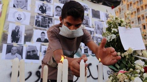 Un uomo accende una candela per ricordare le vittime dell’esplosione a Beirut (Reuters) 
