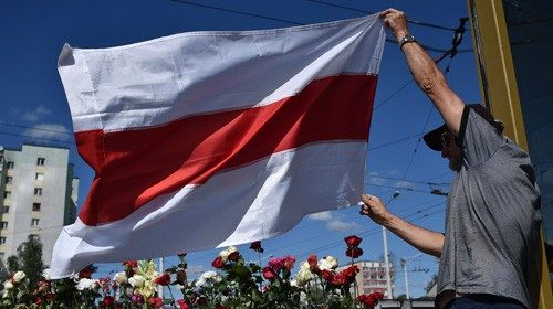 A man waves a flag during a gathering at the site where a protester died last night in Minsk on ...