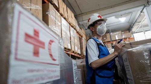 epa08598090 Workers of the Venezuelan Red Cross arrange the boxes with the humanitarian aid that ...