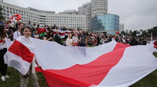 Manifestanti con la bandiera bielorussa nel centro di Minsk (Epa)