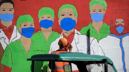 A city worker draws a mural campaigning against the COVID-19 coronavirus on a wall in Jakarta on ...