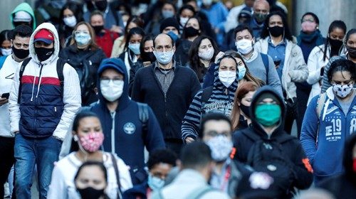 epa08626917 People protected with face masks walk in the southern area of Sao Paulo, Brazil, 26 ...