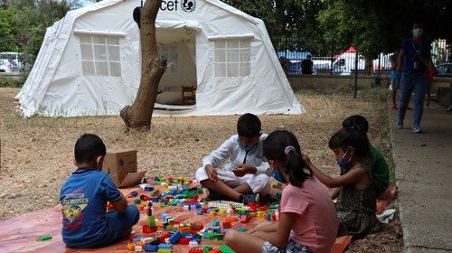 Children play outisde a UNICEF tent put in place to provide psychosocial support to people affected ...