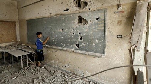 Bambino tra le macerie di una scuola a Gaza Bambino tra le macerie di una scuola a Gaza