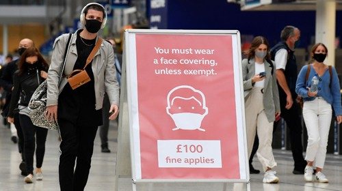 People wearing protective face masks are seen arriving at Waterloo station, the busiest train ...