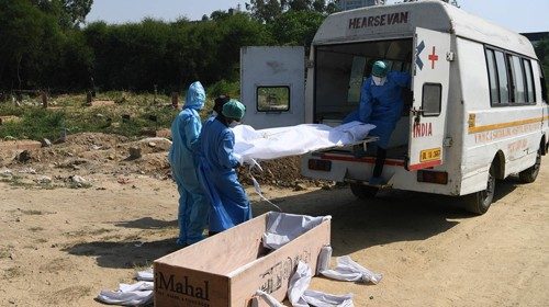 Operatori sanitari trasportano il corpo di una vittima del coronavirus (Afp)