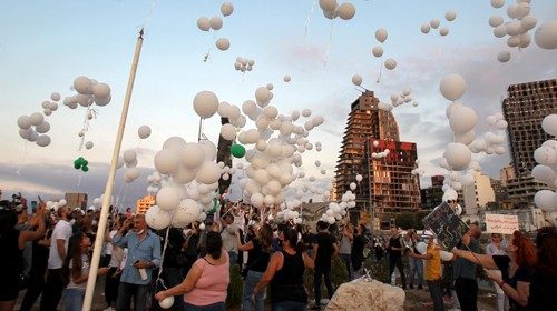 epa08720907 Protesters release balloons with the names of victims of Beirut port blast hang during a ...